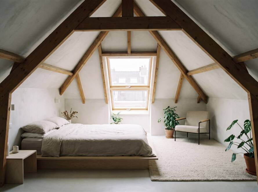 Loft conversion bedroom with exposed roof beams and skylight