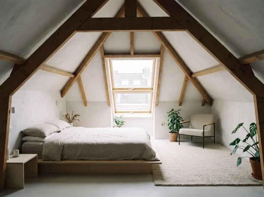 Loft conversion bedroom with exposed roof beams and skylight